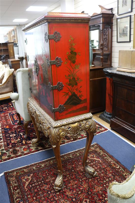 A red lacquer cocktail cabinet on stand, W.105cm